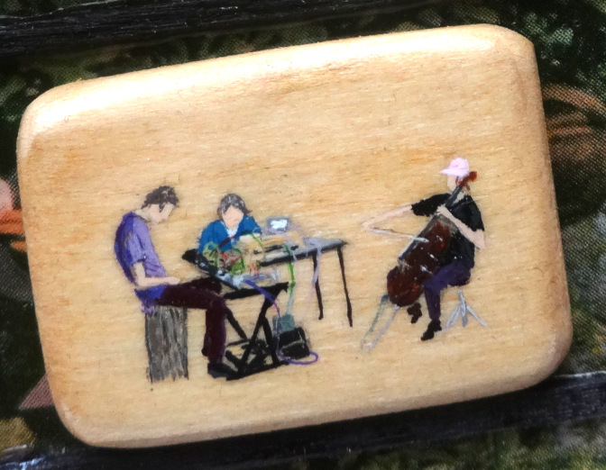 A tiny painting on a piece of wood by Paul Karner of my band A Name For Tomorrow performing at Oakfest in 2023.